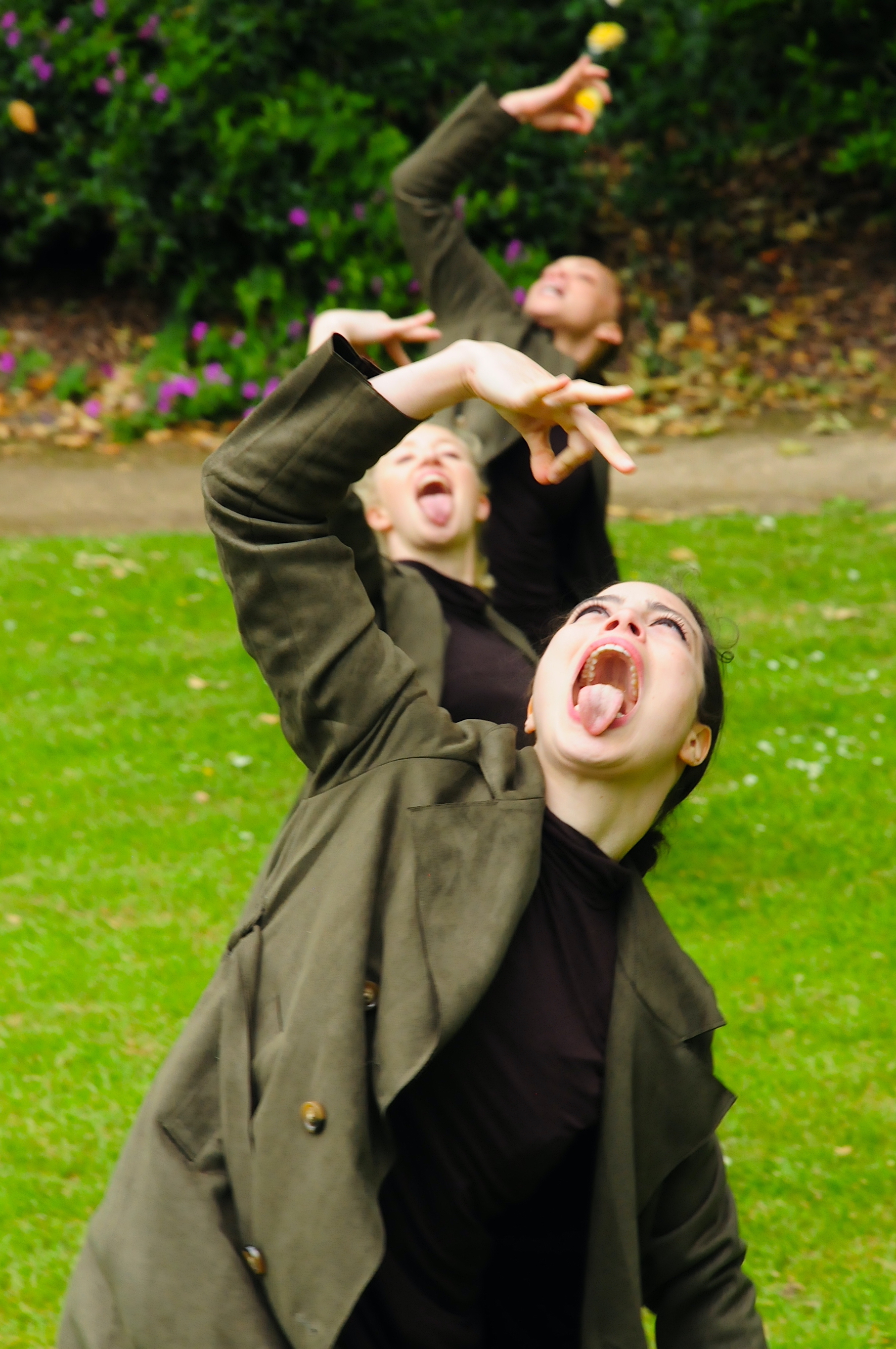 Three dancers hold their hands above their open mouths