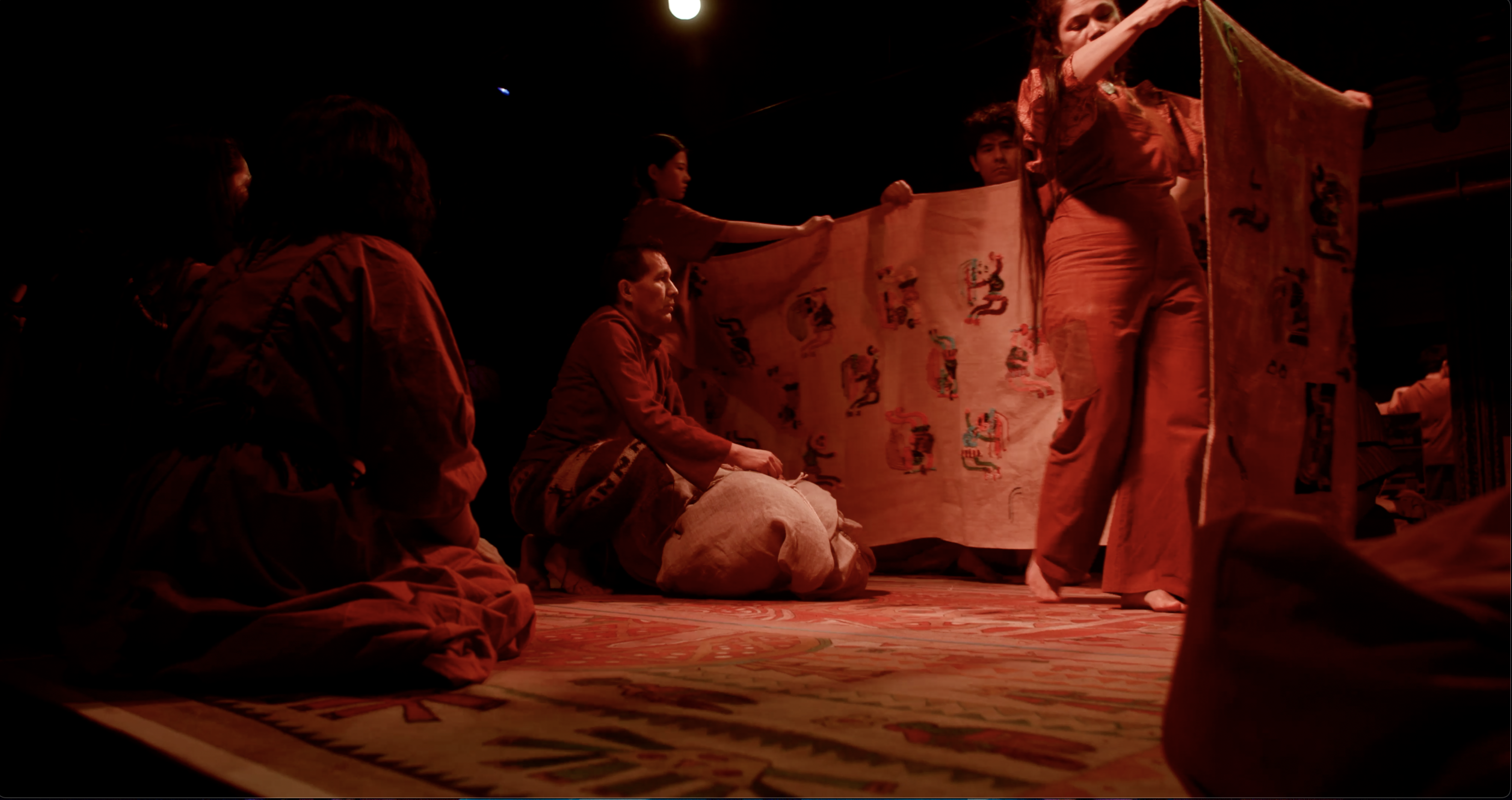 An embroidered mantle is carried around the stage