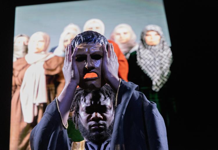 Man lifting a mask with Syrian women behind
